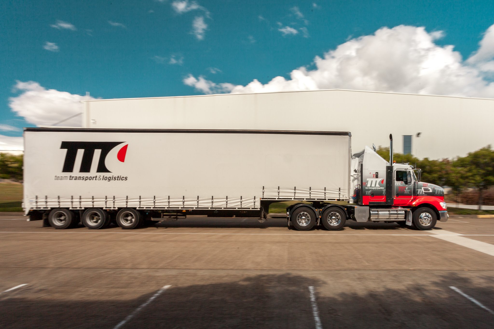 A trailer truck with Team Transport & Logistics branding and logo from the side.