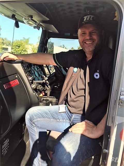 A Team Transport & Logistics employee sits inside the truck used for transportation service.