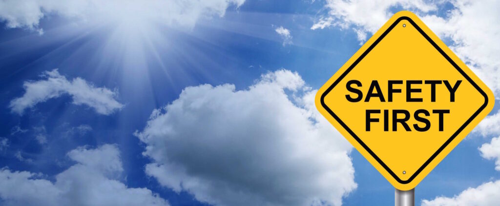 Sign of "Safety First" in rhomb shape of road sign on the background of clouds