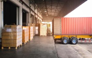 Shipping Cargo Container. Trailer Truck Parked Loading Package Boxes at Dock Warehouse. Cargo Shipment. Supply Chain. Industry Freight Truck Transportation. Shipping Warehousing Logistics.